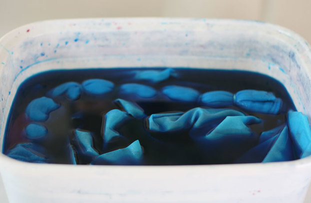 Fabrics soaking in turquoise Procion dye