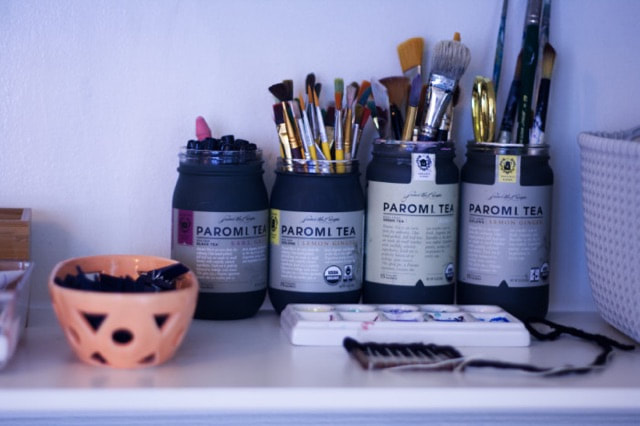 Assortment of artist's brushes in tea jars